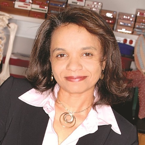 woman in a black sweater and white shirt smiling for the camera