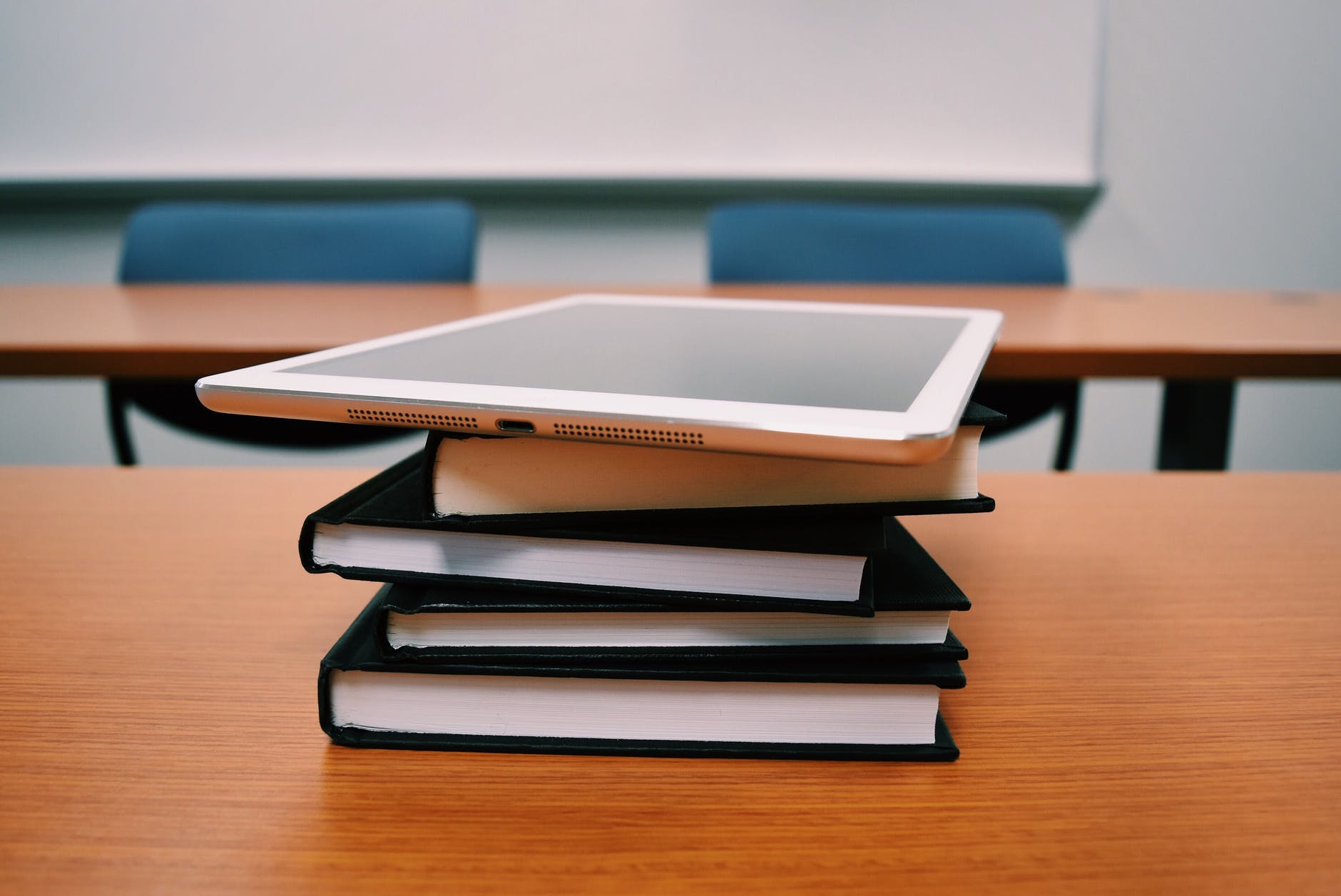 stack of notebooks on a table in a classroom